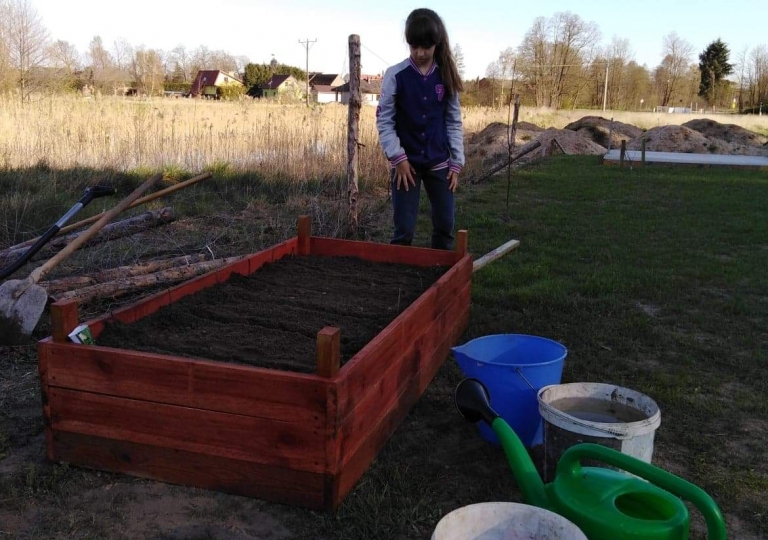 2a sadzi rośliny w ogródku